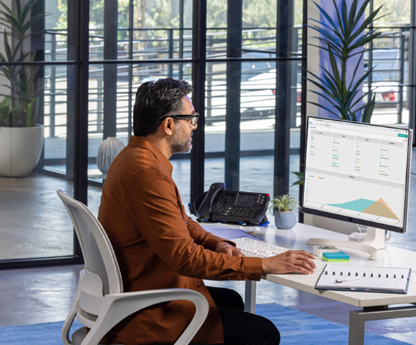 Man sitting at a computer in a care dealership
