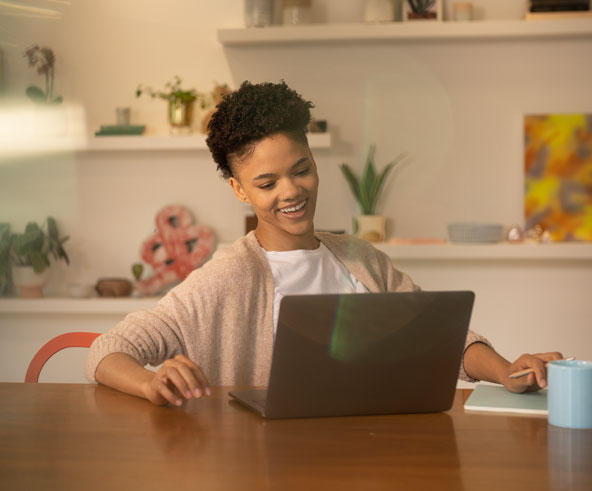 Young woman looking at a laptop, smiling